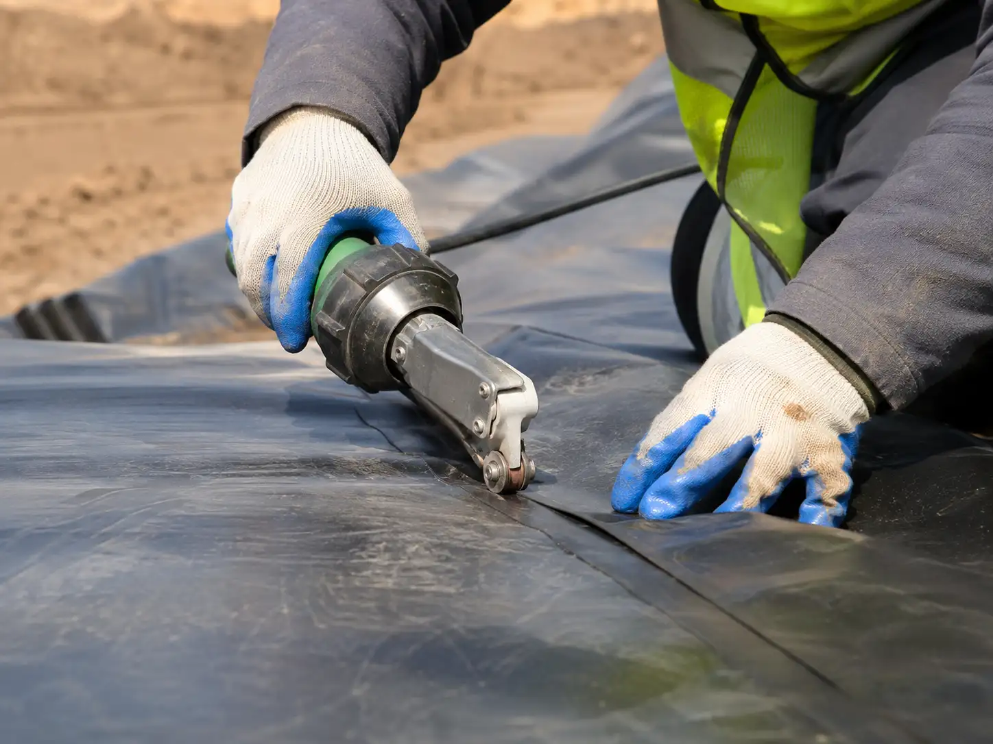 Technicien Geoterra soudant une géomembrane PEHD sur un chantier d'étanchéité au Maroc